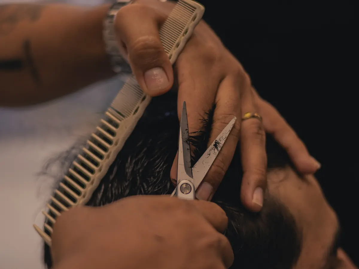 Detalle de tijera y peine trabajando el corte de cabello